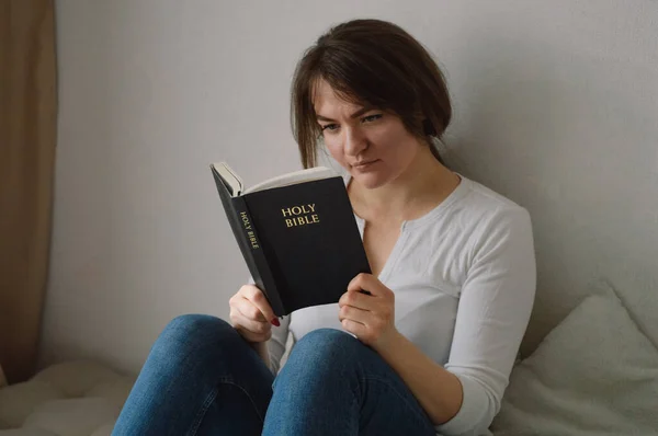 Hristiyan kız İncil 'i elinde tutuyor. Oturma odasında İncil okuyordum. İnanç, maneviyat ve din kavramı — Stok fotoğraf