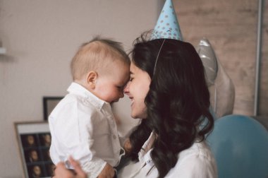 Doğum gününde küçük oğluyla sarılıp oynayan bir kadın. Anneler Günü, aşk, aile kavramı.