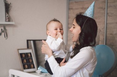 Doğum gününde küçük oğluyla sarılıp oynayan bir kadın. Anneler Günü, aşk, aile kavramı.