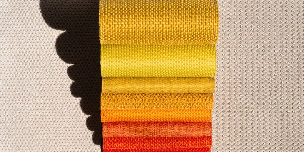 Catalogo di tessuto in tonalità giallo arancio. Campione di tessuto. Contesto industriale . — Foto Stock
