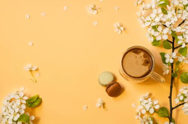 Kahve fincanı ve çiçekler pastel sarı arka planda.. 