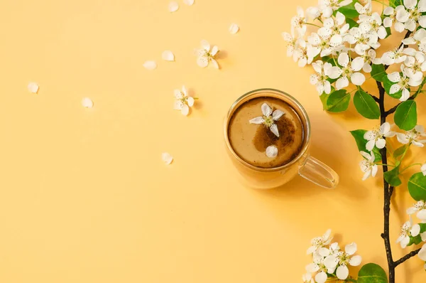 Tasse Kaffee und blühen zarte Blumen auf pastellgelbem Hintergrund. — Stockfoto