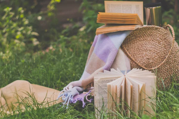 Sacchetto di paglia, libro, cappello e termo tazza in una giornata estiva soleggiata — Foto Stock