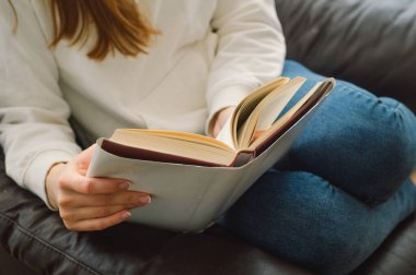 Okuma ve geliştirme. Güzel genç bayan evde bir kitap okuyor. Önemli bir kitap okuyan düşünceli bir kız.