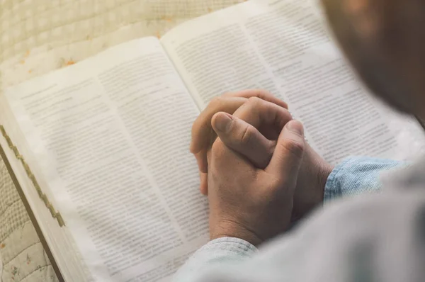 Reading the bible. Prayer. Hands folded in prayer concept. The concept of faith