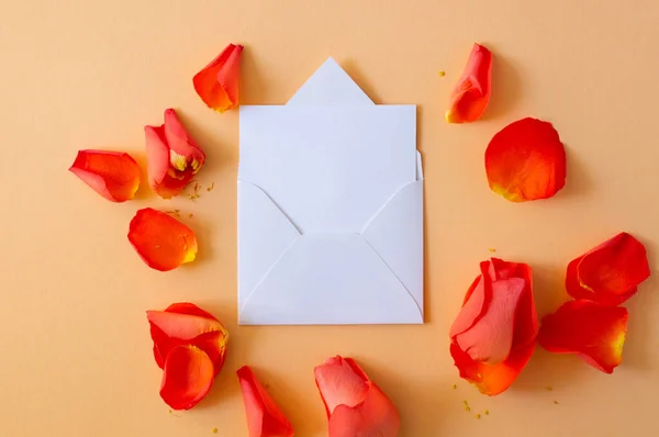 The envelope greeting card, envelope with rose and petals. Overhead top view, flat lay. Copy space.