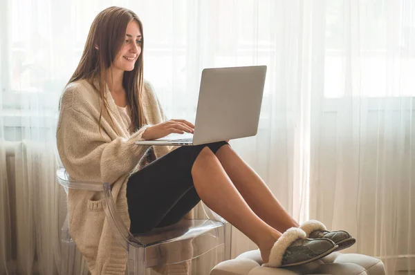 Tecnología, hogar. Mujer trabajando con el ordenador portátil, sentado en la silla en casa — Foto de Stock
