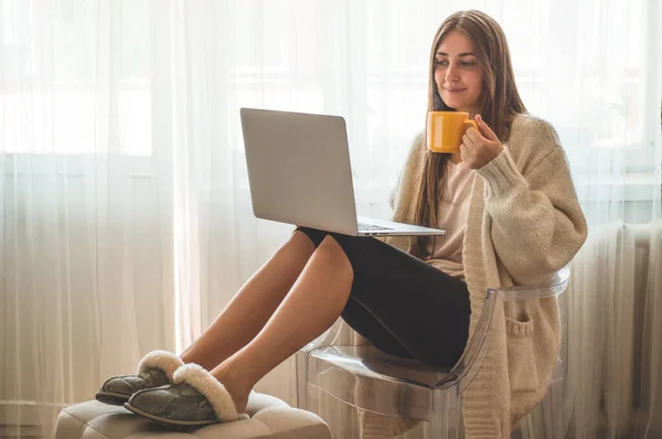 Teknologi, rumah. Perempuan bekerja dengan komputer laptop, duduk di kursi di rumah — Stok Foto