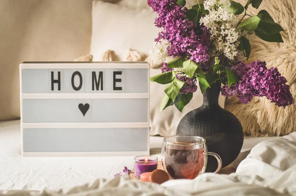 Het tehuis. Stilleven details in het interieur van de woonkamer. Lila bloemen met warme kopje thee. — Stockfoto