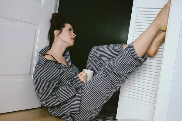 Beautiful young woman sitting with cup of coffee — Stock Photo, Image