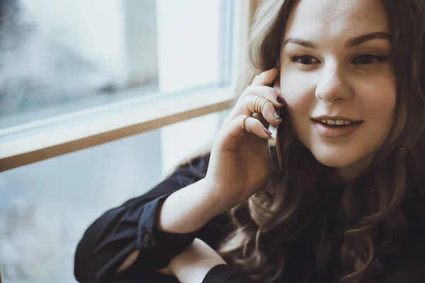 아름 다운 젊은 여 자가 전화에 얘기 하는 바람에 앉아있는 동안 — 스톡 사진