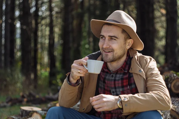 Man cowboy hat drinking morning coffee in countryside