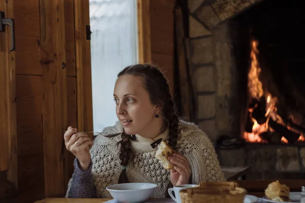 Jovem mulher comendo sopa em um café de madeira no fundo do th — Fotografia de Stock