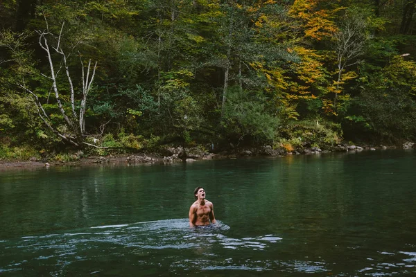 Jovem homem de esportes que toma banho em um lago de montanha no outono — Fotografia de Stock