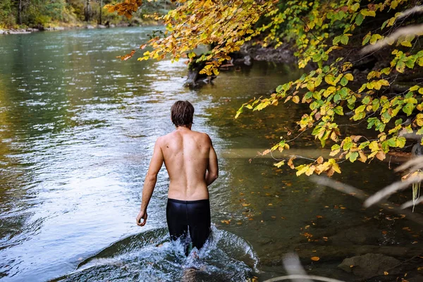 Jovem homem de esportes que toma banho em um lago de montanha no outono — Fotografia de Stock