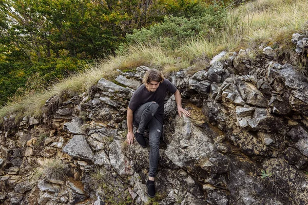 Hombre joven escalando en una pared de piedra caliza . — Foto de Stock