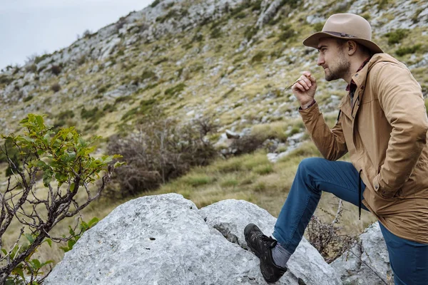 Νεαρός άνδρας με το καπέλο που αρχίζει μια περιπέτεια στο βουνό στο Monten — Φωτογραφία Αρχείου