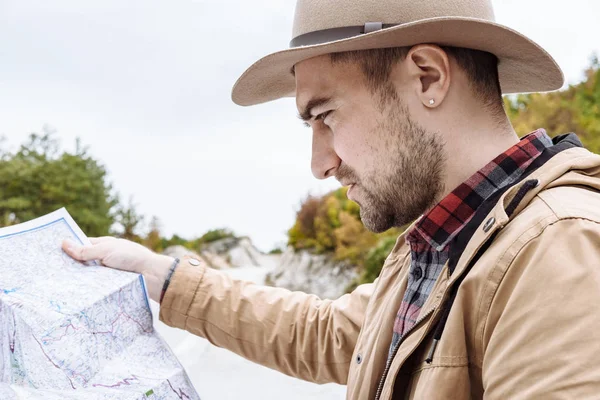 Jóképű férfi a térképpel a kézben mellette, itt: Mont-ban autót — Stock Fotó