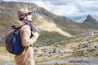 Adam Gezgin şapka ve tepenin üstüne D seyir sırt çantası