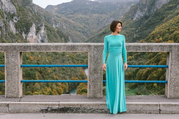 Köprüde zarif bir turkuaz elbiseli genç kadın — Stok fotoğraf