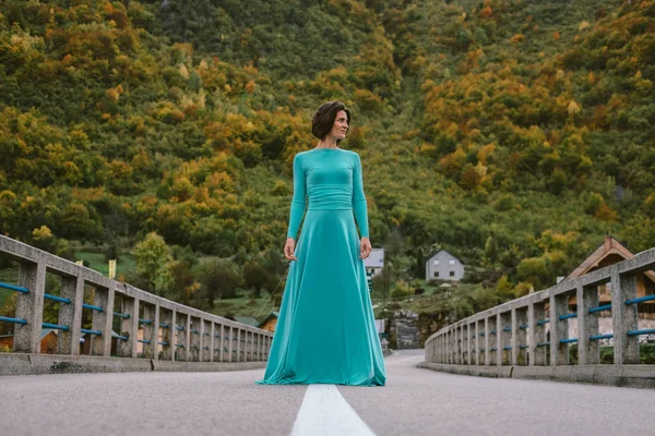 Jovem mulher em um elegante vestido turquesa na ponte — Fotografia de Stock
