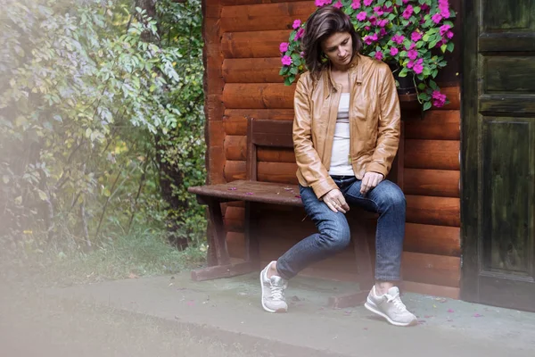 Mujer atractiva joven en una chaqueta de cuero en el otoño — Foto de Stock