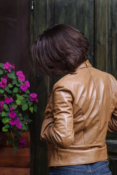Mujer atractiva joven en una chaqueta de cuero en el otoño — Foto de Stock