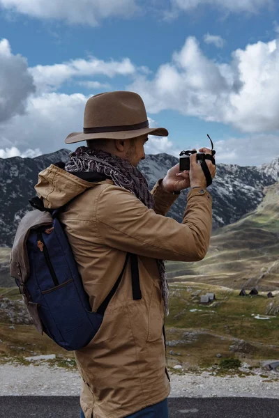 Fotógrafo en sombrero tomando una foto en las montañas de otoño Durmit —  Fotos de Stock