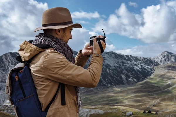 Fotógrafo en sombrero tomando una foto en las montañas de otoño Durmit —  Fotos de Stock