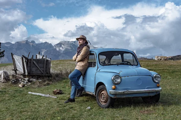 Viaggiatore accanto alla vecchia macchina blu sullo sfondo della bella — Foto Stock