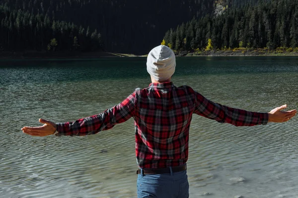 Hipster viajante levantou as mãos contra Black Lake, Durmitor Natio — Fotografia de Stock