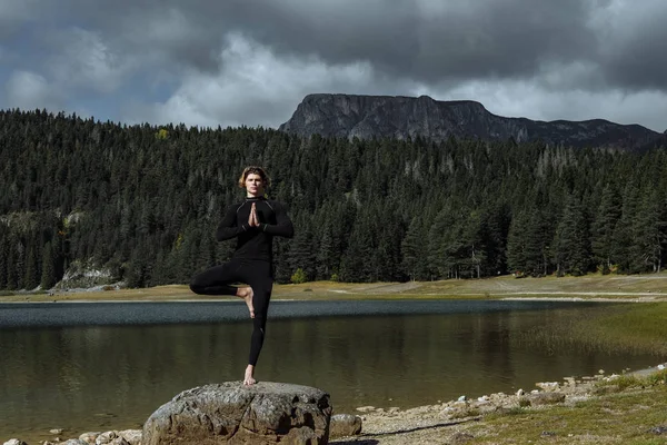 Člověk praktikující jógu poblíž jezera černé podzimní vydání Durmitor National — Stock fotografie