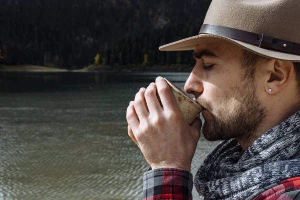 Hopster viaggiatore con il cappello sta bevendo caffè e godersi il — Foto Stock