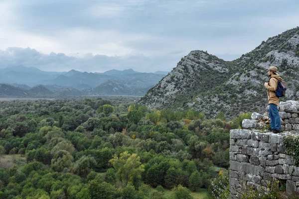 Ο άνθρωπος ταξιδιώτη με καπέλο και σακίδιο απολαμβάνοντας το φυσικό περιβάλλουν — Φωτογραφία Αρχείου