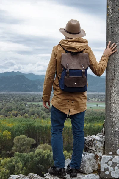 Чоловік мандрівник з капелюхом і рюкзаком насолоджується природним оточенням — стокове фото
