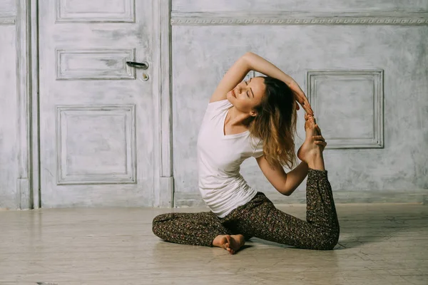 Junge Frau übt in einem Yoga-Studio. — Stockfoto