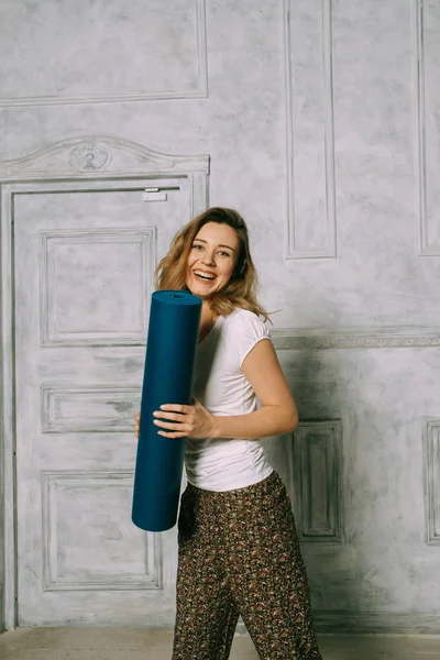 Young attractive woman holding yoga mat — Stock Photo, Image