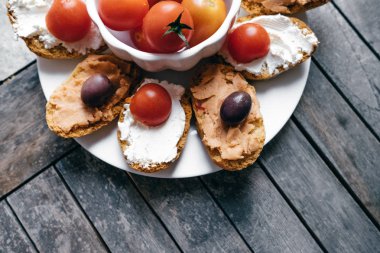 Bruschetta üstten görünüm yumuşak krem peynir, zeytin, kiraz