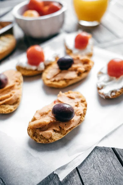 Closeup Bruschetta com queijo creme macio, azeitonas, tomate cereja — Fotografia de Stock