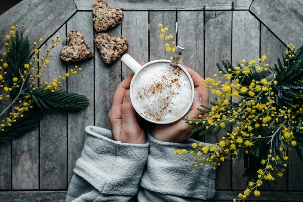 Mano donna con Cappuccino con cannella in tazza bianca con hea — Foto Stock