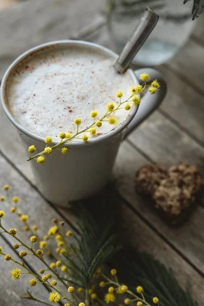 Vertikales Foto einer Tasse Cappuccino mit Zimt und Mimose auf — Stockfoto