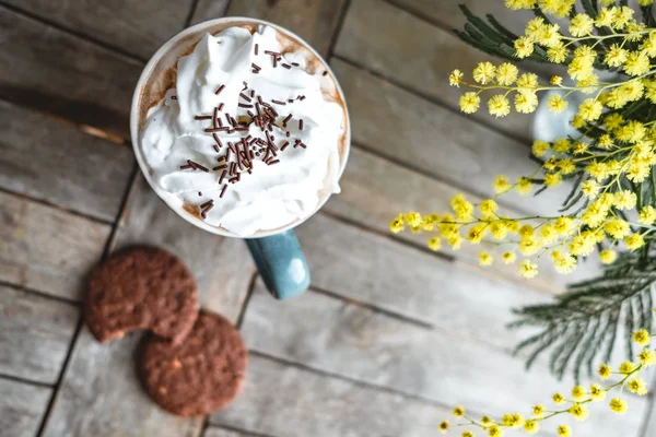 Draufsicht auf Sahne-Kakao und Kekse auf einem Holztisch mit Mimosen — Stockfoto