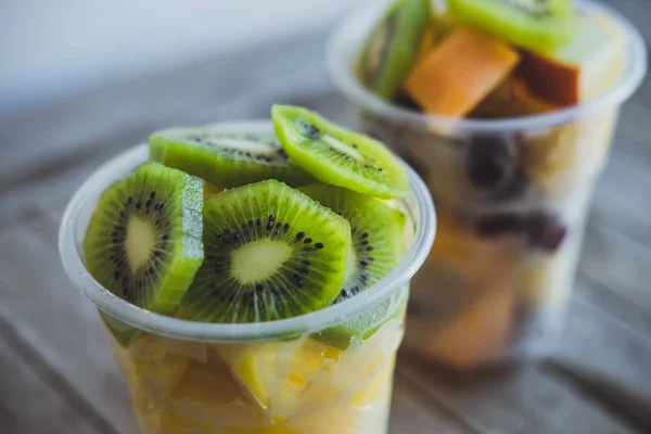 Primer plano Frutas cortadas: kiwi, piña, mandarinas, manzanas, melón en —  Fotos de Stock