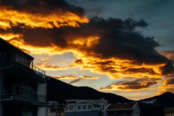 Abendsonne über einer Häuserzeile am Stadtrand, orangefarbener Himmel — Stockfoto