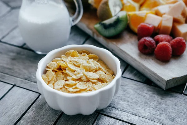 Bílá miska s corn Flakes a mléka a čerstvé krájené ovoce: ra — Stock fotografie