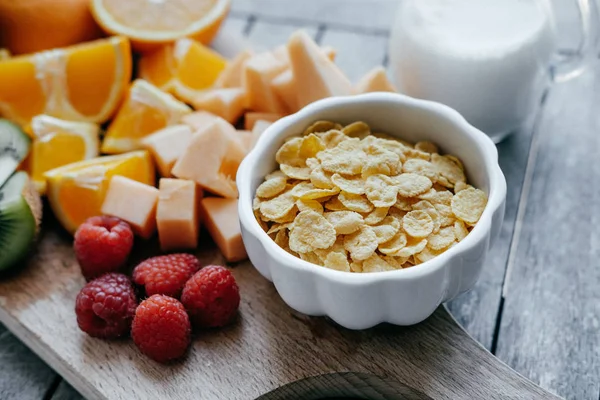 Bílá miska s corn Flakes a mléka a čerstvé krájené ovoce: ra — Stock fotografie