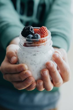 Dikey fotoğraf çocuk eller pudingle chia tohum ile yoğurt bir