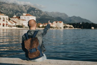 Adam Gezgin adam elini denize yakın gösterilmesini sırt çantası ile.