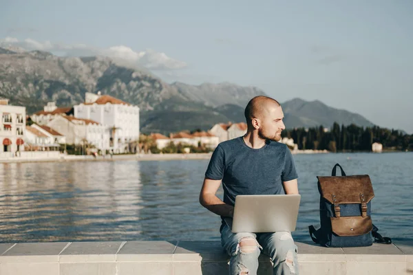 젊은 사람이 앉아서 바다 근처 노트북 컴퓨터 작업 — 스톡 사진