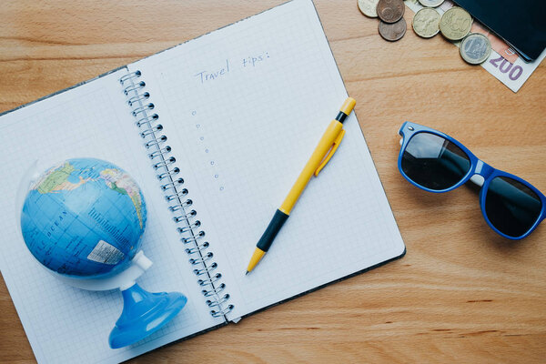 Flat lay travel concept with coins, cards, mobile phone, globe and coffee. Top view
